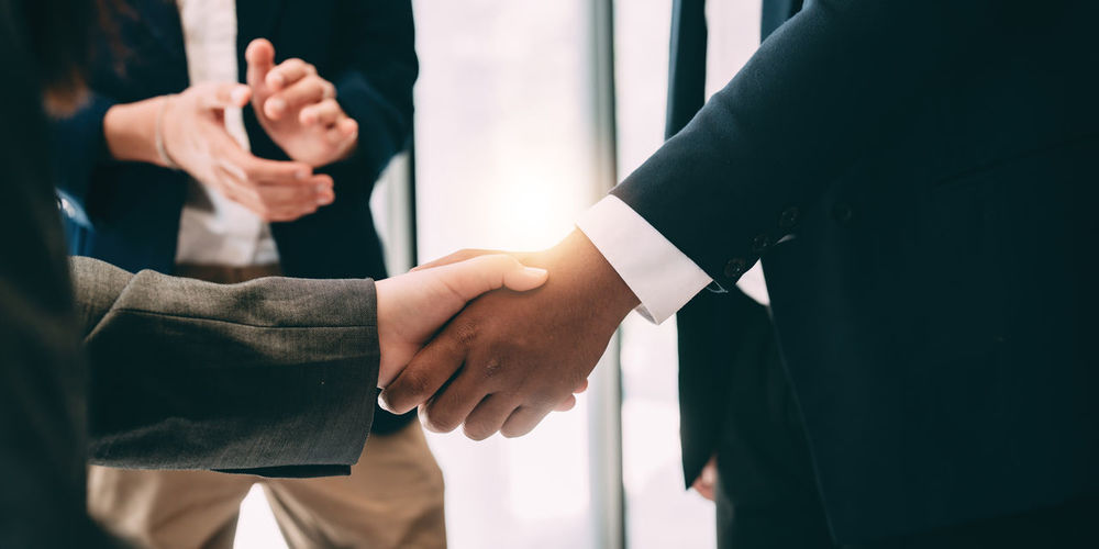 Midsection of businessmen shaking hands