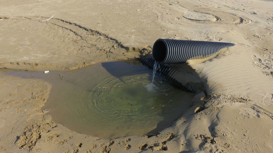 High angle view of water coming out from pipe at beach