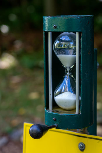 Close-up of yellow clock on sand