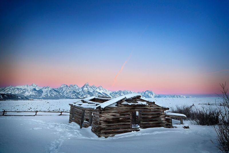 Wooden shed on snow covered landscape