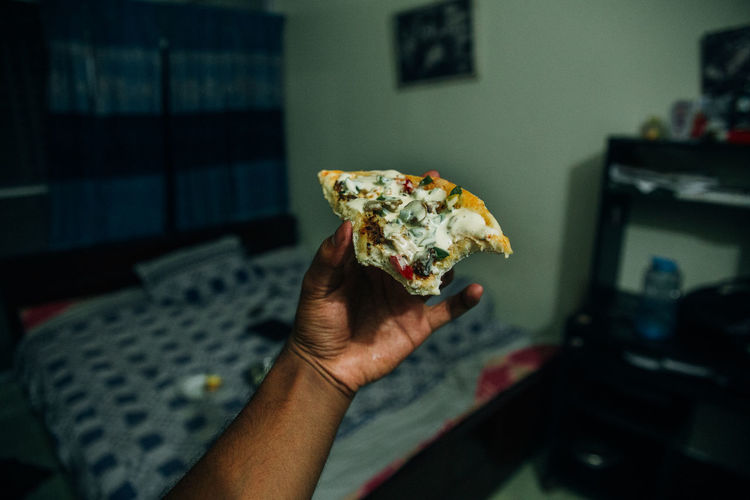 A bitten pizza on a hand 