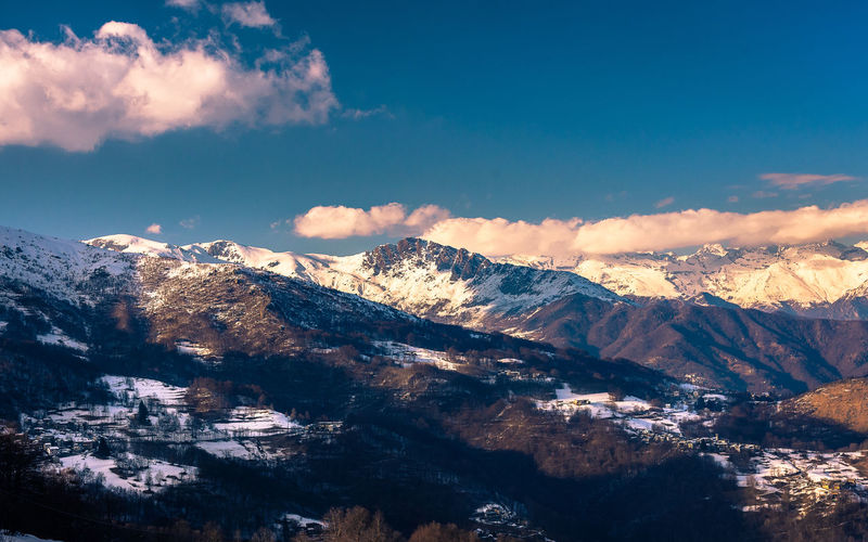 Scenic view of mountains against blue sky during winter