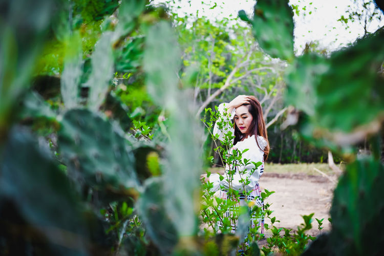 Portrait of woman standing by plants