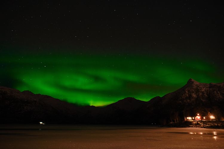 Scenic view of polar light above mountains against sky at night