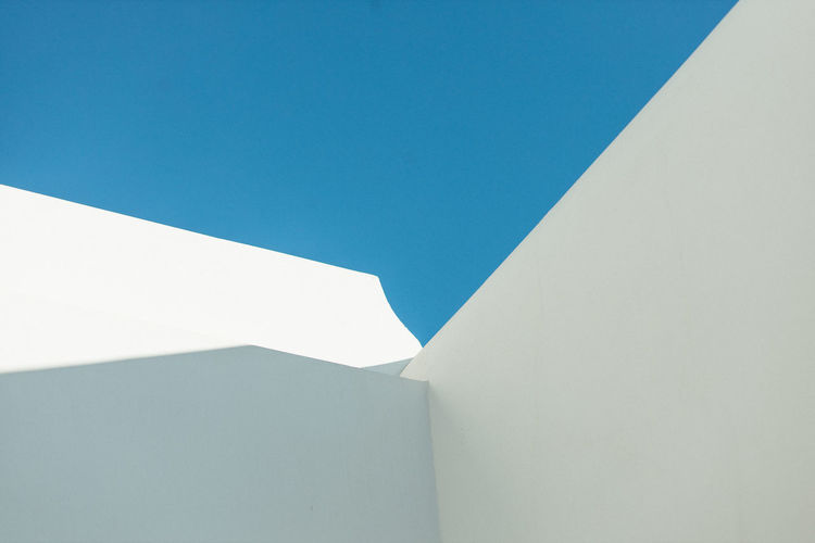 Low angle view of white building against clear blue sky