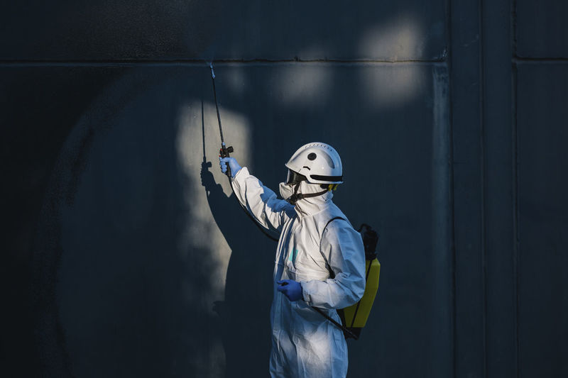 Closeup of a firefighter disinfecting the walls of a building