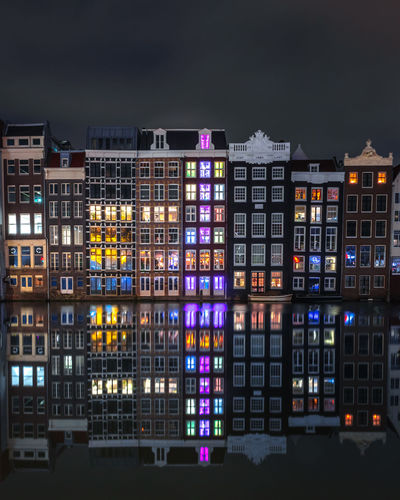 A very calm night in amsterdam with smooth reflections of the buildings on the water.
