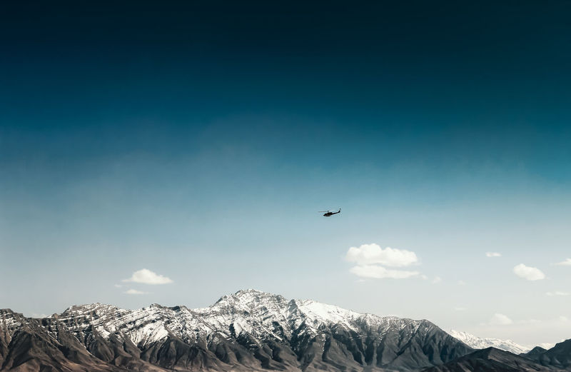 Coalition helicopter over snowy afghanistan mountains. helicopter in afghanistan as part of the nato