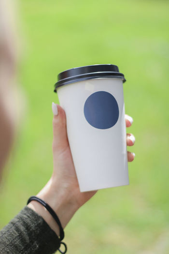 Midsection of person holding coffee cup