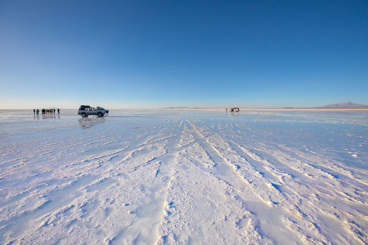Scenic view of salt flat against clear blue sky