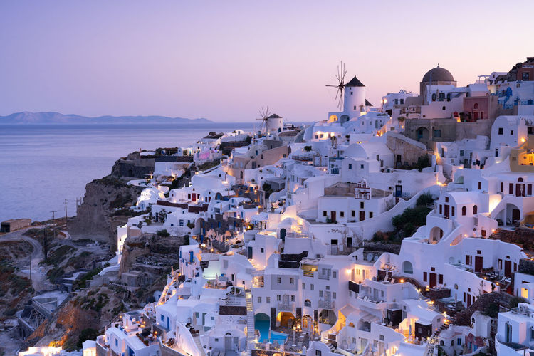 Houses by sea at santorini during sunset