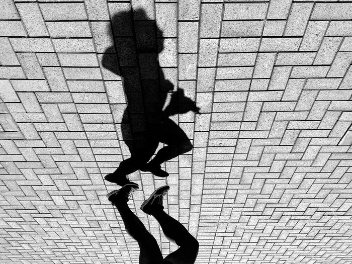 Shadow of man and woman walking on street