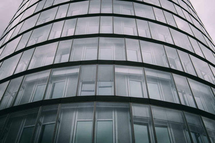 Low angle view of glass building against sky