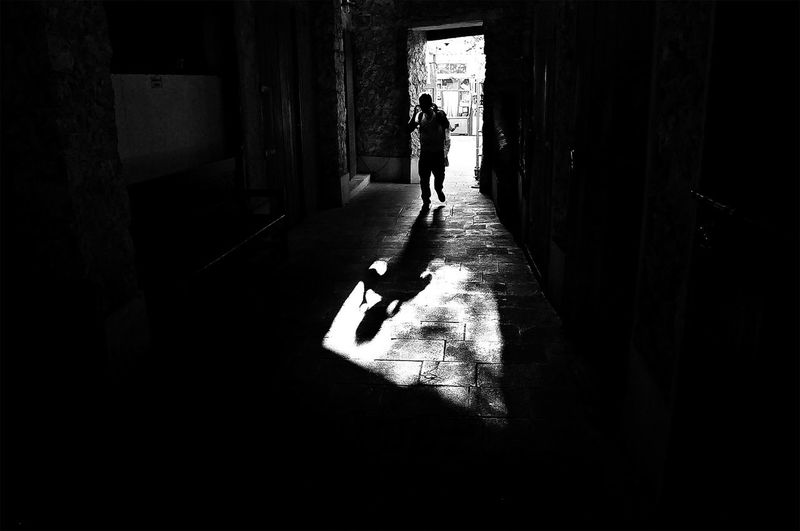 Silhouette woman walking in corridor of building