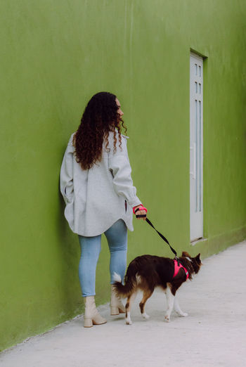 Rear view of woman with dog on floor