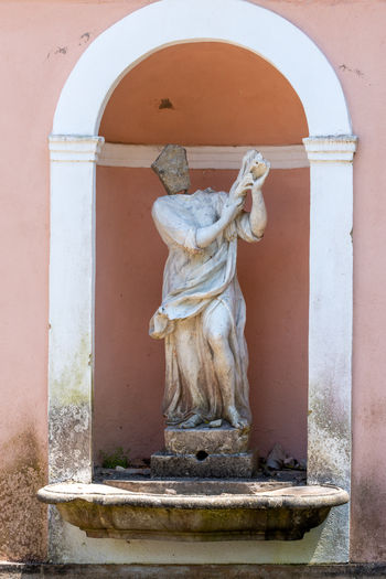 Statue against wall of building