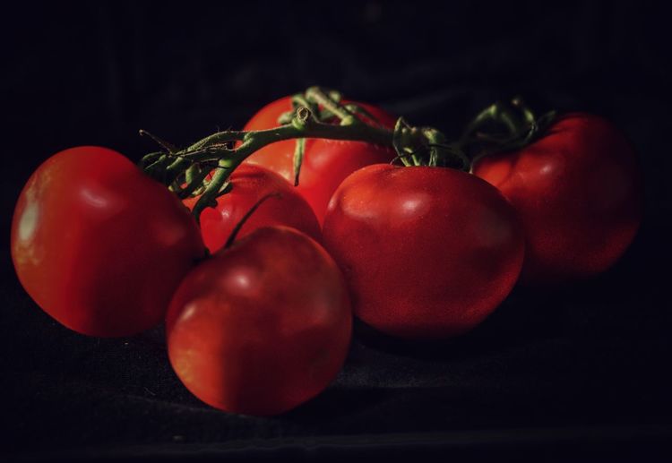 Close-up of cherry tomatoes on table against black background