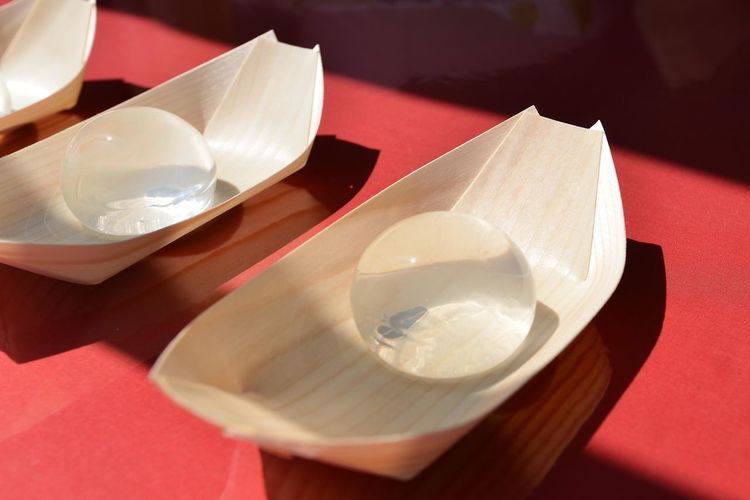 Close-up of transparent balls in paper boats on table