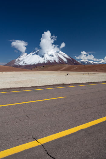 Empty road by mountain against sky