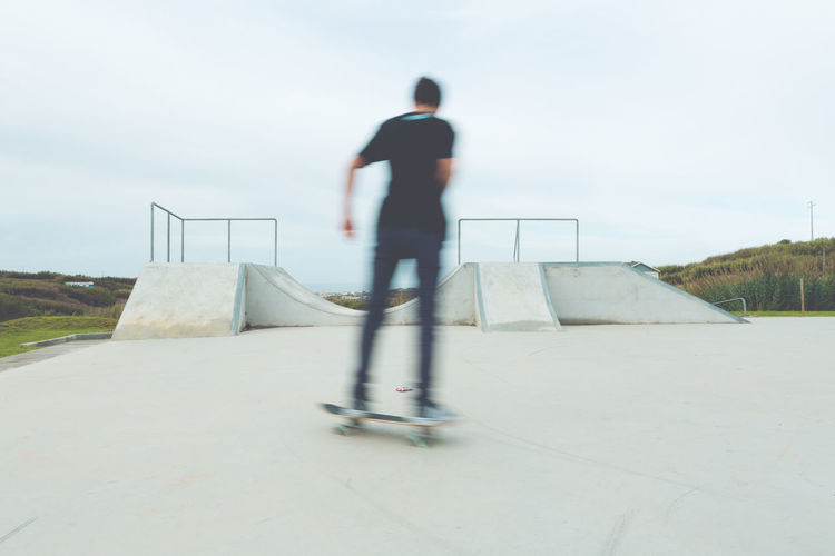 Blurred image of man skateboarding at park