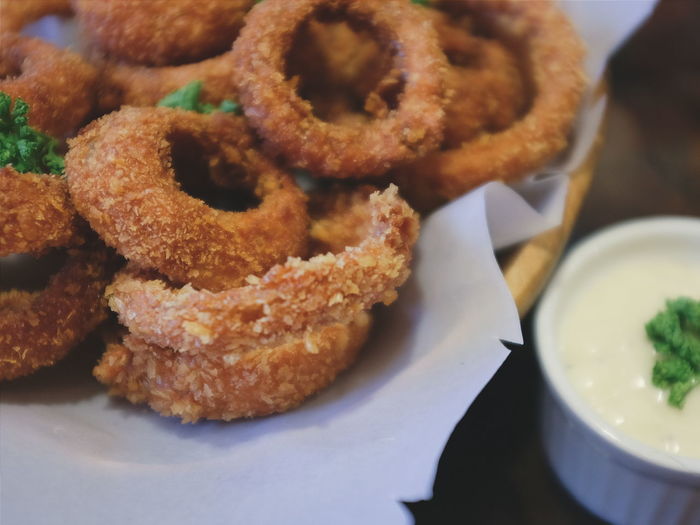 Close-up of onion rings in plate with sauce