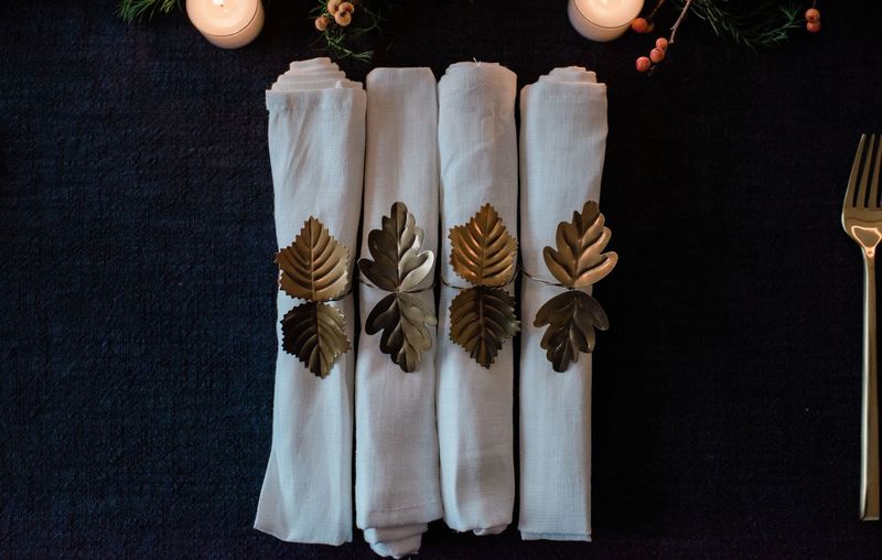 Row of gold and white napkins on a decorated dinner table setting
