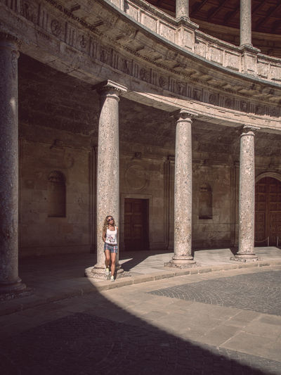 Woman walking in front of built structure