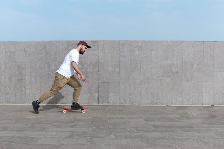 Young man riding skateboard on the street