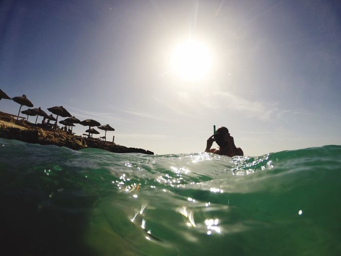 Man snorkeling in sea against sky