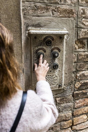 Woman pressing old button on wall