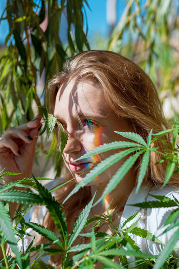 Woman looking away while holding plant