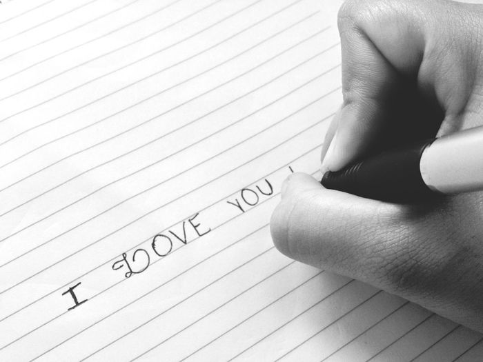Cropped image of person writing on book