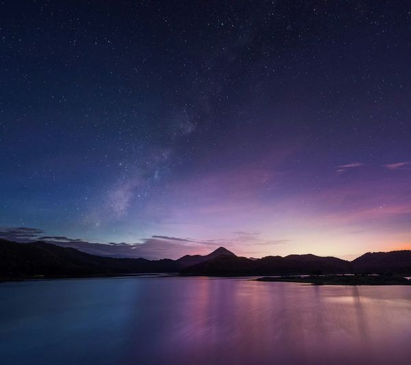 Long exposure shot of milky way over majestic mountain lake