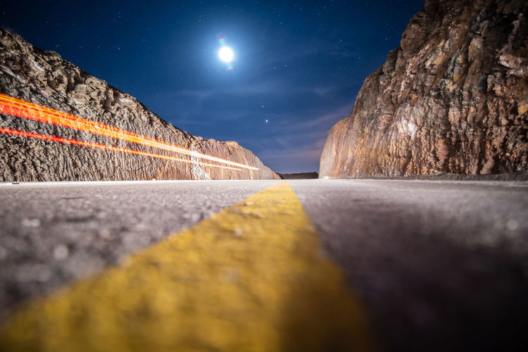 Surface level of road against sky at night