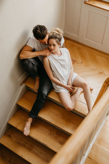 Couple kissing on wooden floor at home