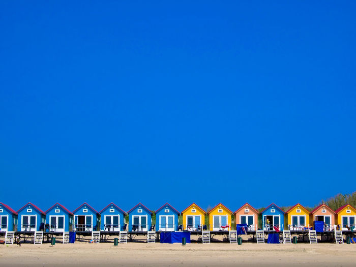 Beach houses against clear blue sky