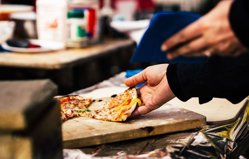 Cropped image of man with pizza in restaurant