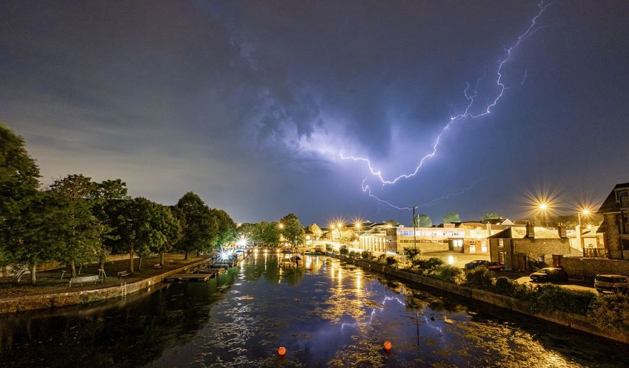 Panoramic view of lightning in city against sky at night