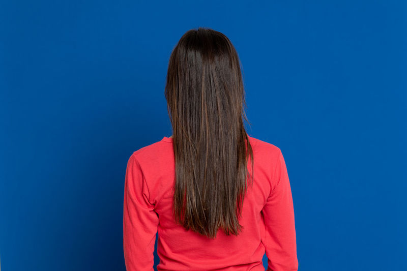 Rear view of woman against blue background