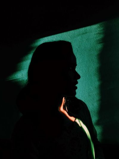 Close-up of woman against shadow at night