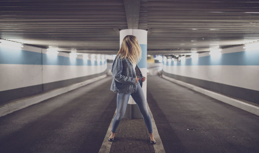 Woman standing in illuminated subway station