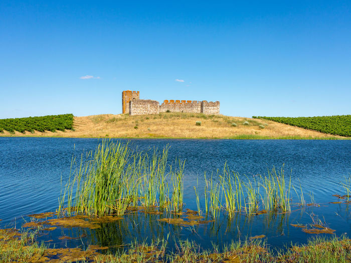 Scenic view of lake against clear blue sky