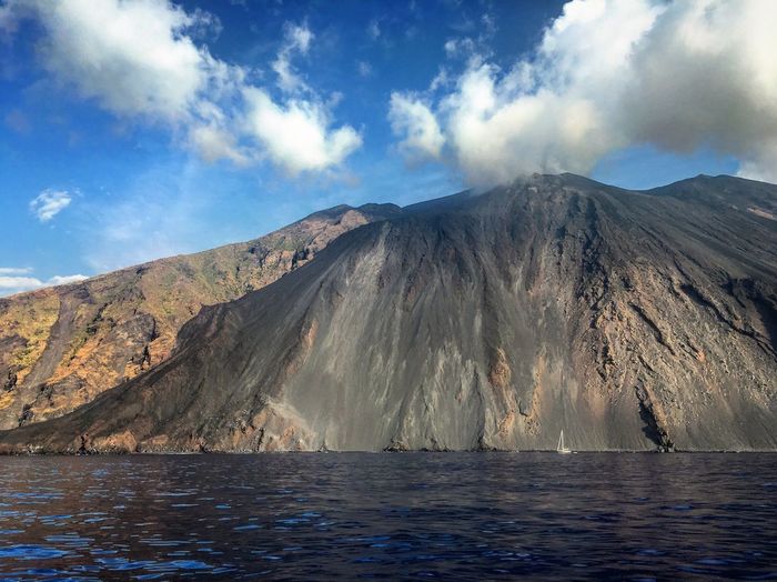 Stromboli volcano by sea against sky