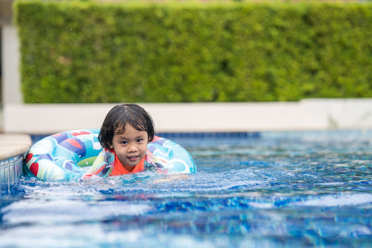 Little adorable girl have fun at outdoor swimming pool