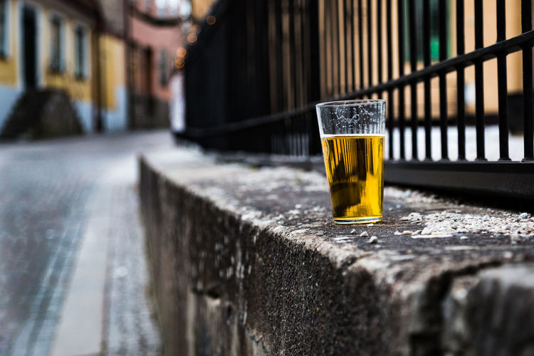 Close-up of beer glass on retaining wall