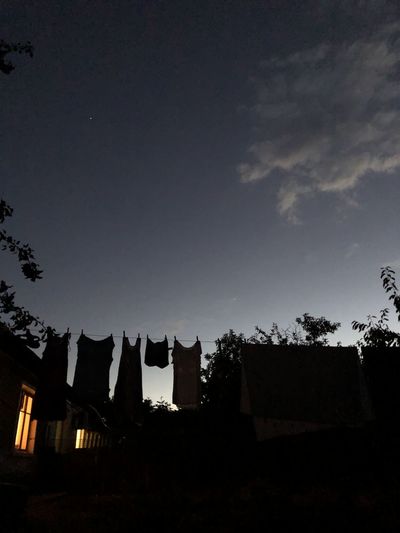 Low angle view of silhouette buildings against sky at night