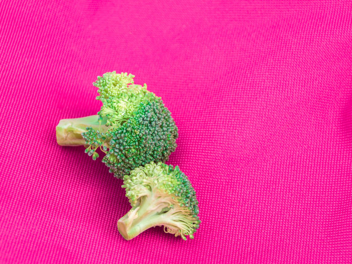 High angle view of broccoli on pink fabric