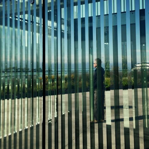 Reflection of man on glass building