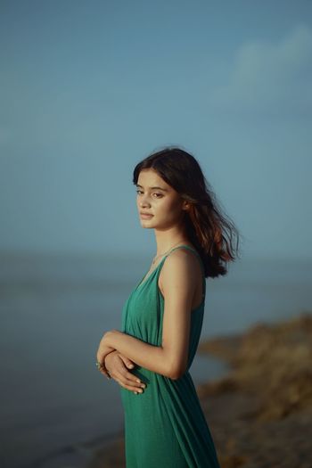 Young woman standing against sea