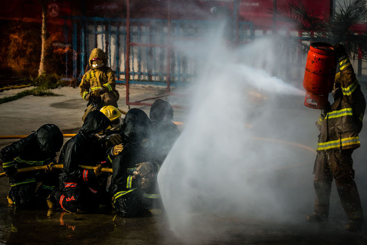 Firefighter spraying water on fire